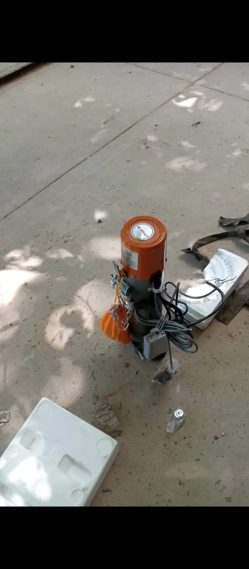 Motor naranja sobre piso con cables, al aire libre
