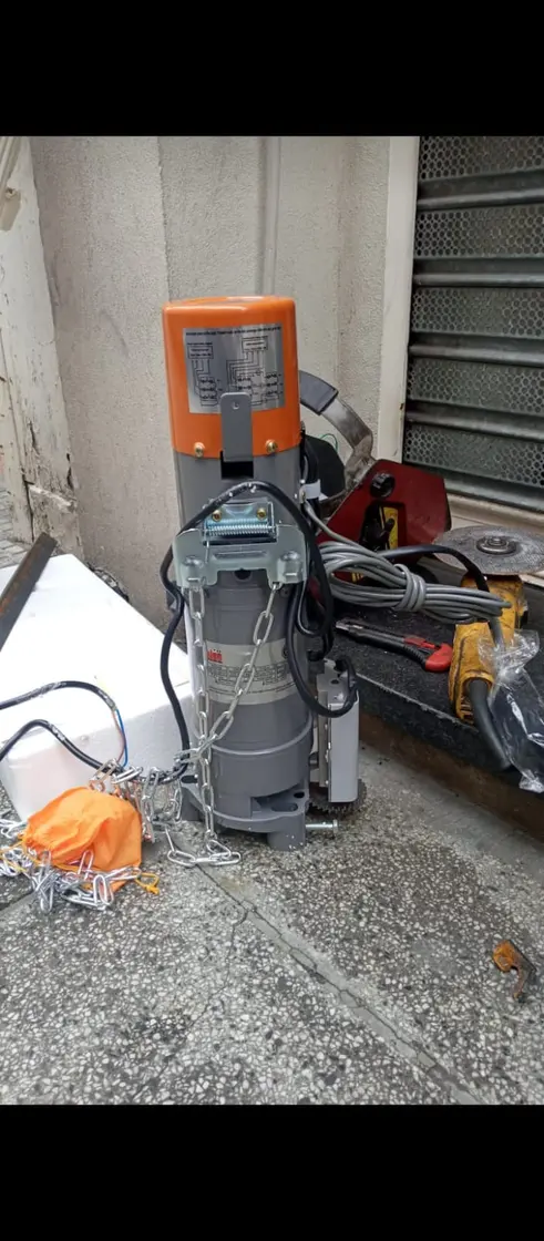 Motor naranja con cadena sobre vereda, vista de frente